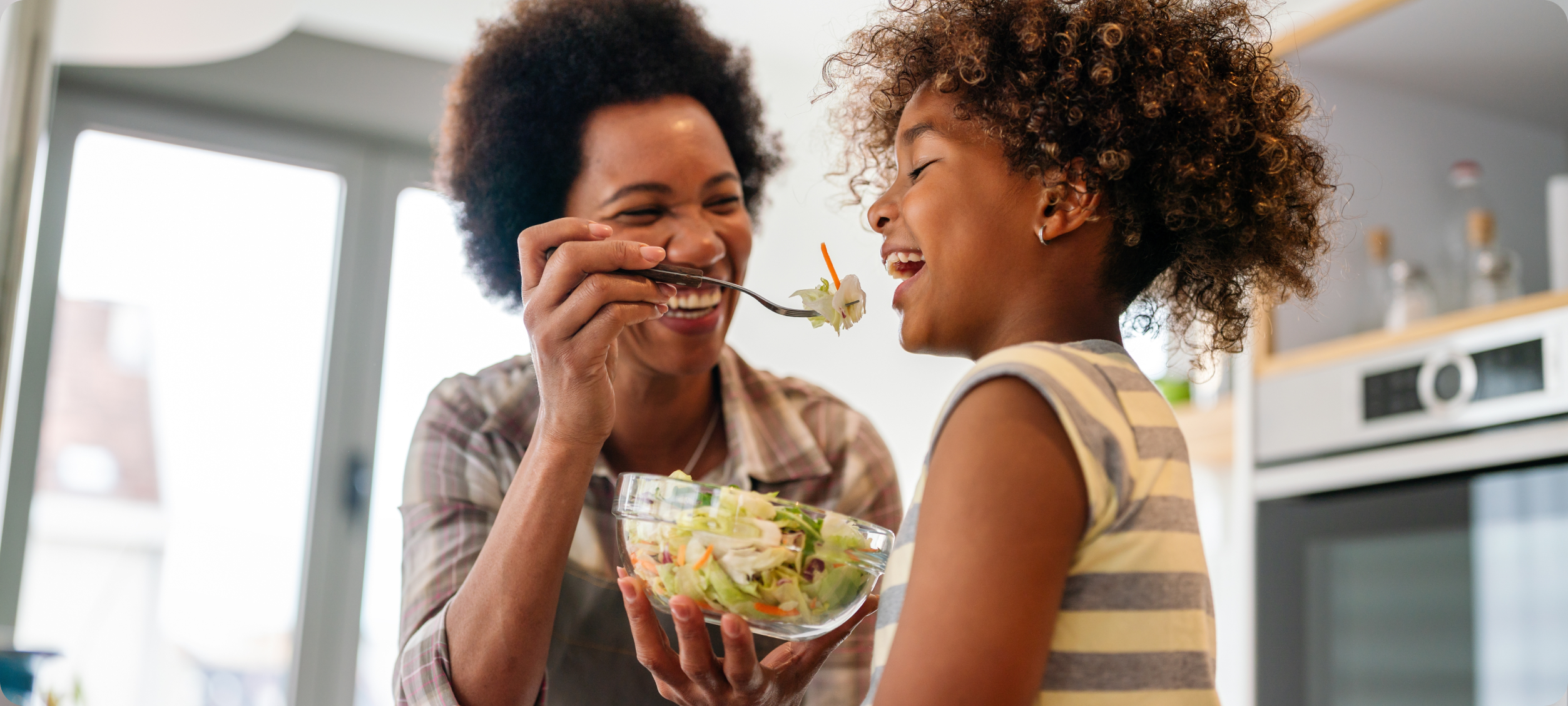 Mum feeding child a salad