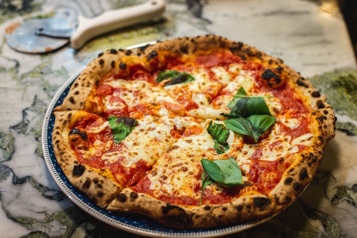 Pizza topped with fresh rocket, mozzarella and tomatoes